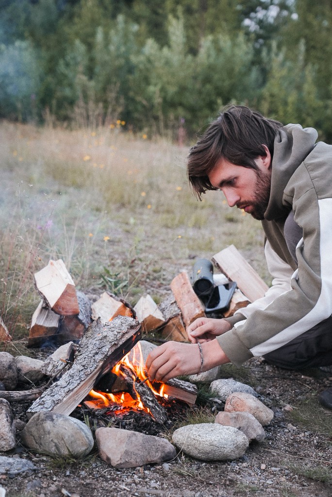 Tristan starting a campfire outdoors
